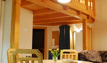 Esstisch im hohen und offenen Wohnraum mit Galerie