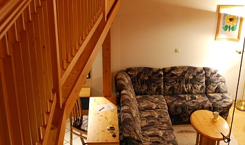 Oben - Offener Schlafraum auf der Galerie, unten - Wohnraum mit Couch